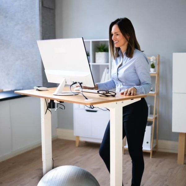 Woman,Using,Adjustable,Height,Standing,Desk,In,Office,For,Good